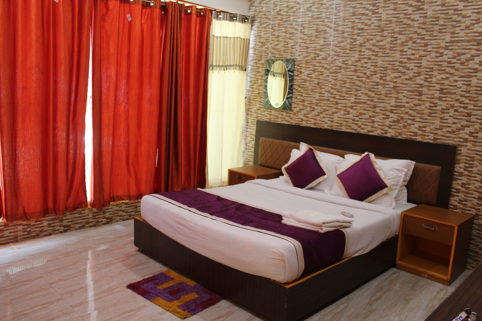Guest bedroom with red curtains and purple accents